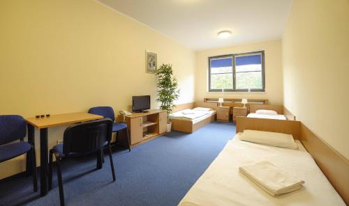 a room with two beds and a desk and a table at Gdańska Szkoła Szermierki in Gdańsk