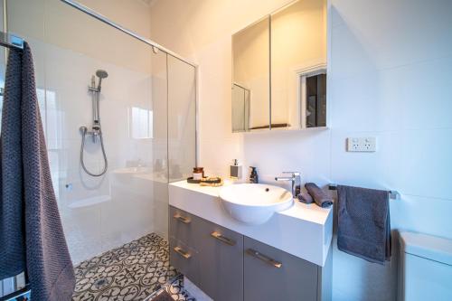 a bathroom with a sink and a shower at Archer St Heart of North Adelaide Balcony 65TV in Adelaide
