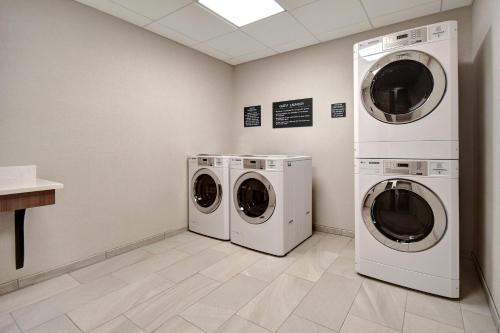 two washing machines and a washer and dryer in a room at Holiday Inn - Erie by IHG in Erie