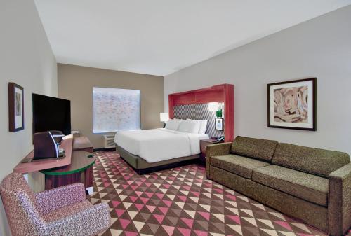 a hotel room with a bed and a couch at Holiday Inn - Erie by IHG in Erie