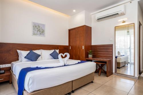 1 dormitorio con 1 cama grande y escritorio en Oshin Hotel en Wayanad