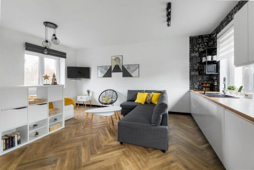 a living room with a couch and a table at Słone Residence Apartamenty & Beer SPA in Kudowa-Zdrój