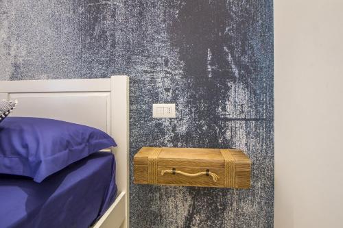 a room with a bed and a wooden trunk next to a wall at Primopiano Luxury Accommodations in Vieste