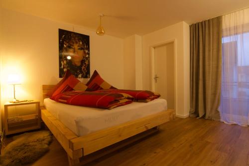 um quarto com uma cama com almofadas vermelhas em Ferienwohnung Dreiländereck 1 em Lörrach