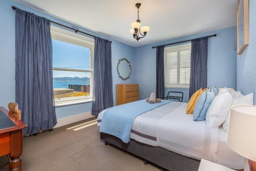 a bedroom with a bed and a large window at Maison del Mar in Hobart