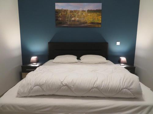 a bedroom with a white bed with two night stands at La Roche en Ardenne , welcome in La Roche-en-Ardenne