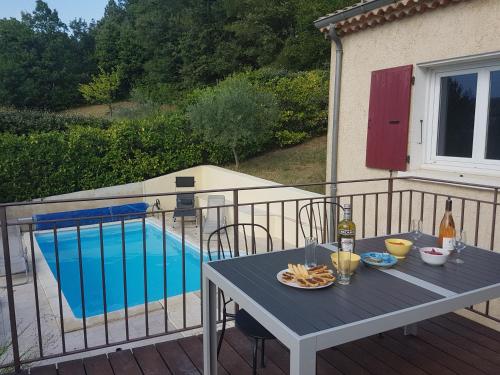 d'une table et de chaises sur un balcon avec piscine. dans l'établissement MAISON PROVENCE AVEC PISCINE PRIVATIVE, à Nyons