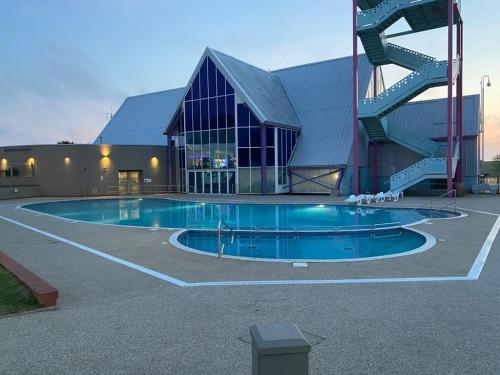 a large building with a swimming pool in front of a building at Sussex by the sea holiday home in Hastings