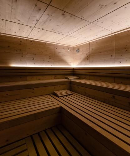 an empty sauna with wooden benches in a room at Hotel Mühlenerhof in Campo Tures