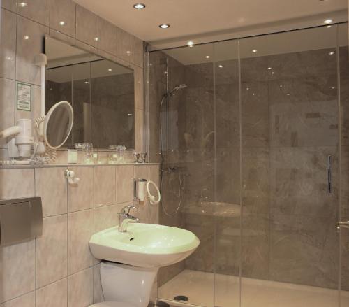 a bathroom with a shower and a sink and a toilet at Aalto Hotel in Hannover