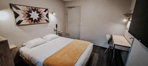 a bedroom with a bed and a desk and a painting at Auberge de la Rivière in Foncine-le-Haut