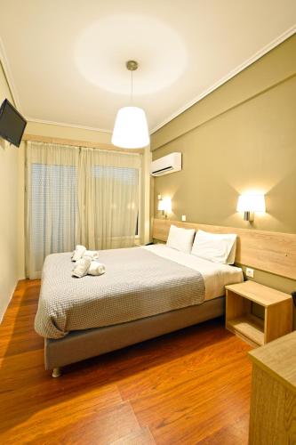 a bedroom with a bed with a stuffed animal on it at John's Hotel in Chalkida