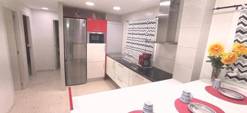 a kitchen with a stainless steel refrigerator and a counter at Apartamento Tobias, muy cerca de la playa centro in Villajoyosa