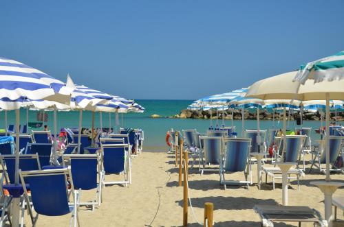 a bunch of chairs and umbrellas on a beach at Grand Hotel Montesilvano in Montesilvano
