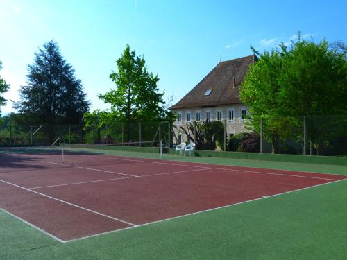 a tennis court in front of a house at Domaine du Manoir in Les Avenières