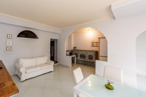 a living room with a white couch and a table at Tenuta San Giorgio in Serravalle Scrivia