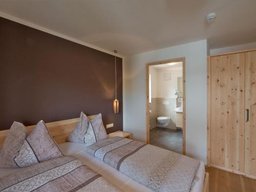 a bedroom with two beds and a bathroom at Naturhotel Edelweiss in Terento