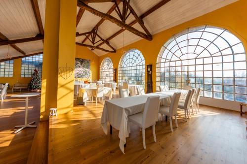 a dining room with white tables and white chairs at Tenuta San Giorgio in Serravalle Scrivia