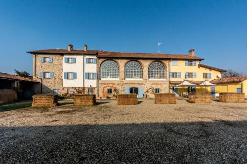 a large building with hay bales in front of it at Tenuta San Giorgio in Serravalle Scrivia