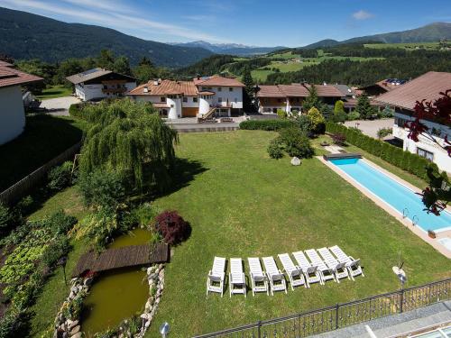 an aerial view of a house with a swimming pool and a yard at Naturhotel Edelweiss in Terento