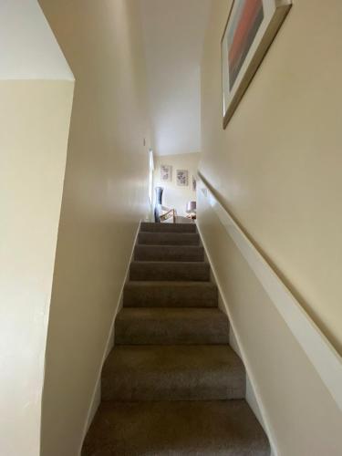 a staircase in a house with a picture on the wall at Hector's Bothy flat in Kyle of Lochalsh