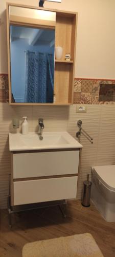 a bathroom with a sink and a mirror and a toilet at Duomo Rooms Cefalù in Cefalù