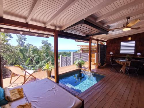 un patio con piscina en una terraza de madera en EDEN FOREST Villas en Pointe-Noire