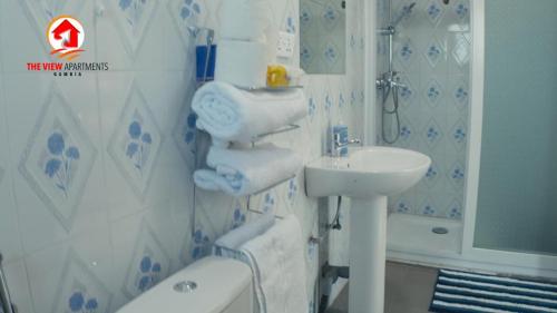 łazienka z umywalką, toaletą i wanną w obiekcie The View Apartments w mieście Brusubi