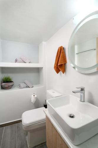 a white bathroom with a sink and a mirror at Niki Mountain House in Kamariótis