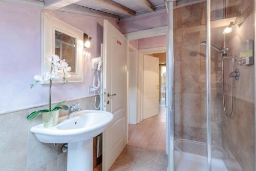a bathroom with a sink and a shower at Casolare dei Colli, Panoramic Private Pool, Lavish Interiors and a Gourmet Kitchen in Camaiore