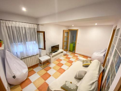 ein Wohnzimmer mit Sofa und Fernseher in der Unterkunft La Casita de Colores de Alicia in Cuenca