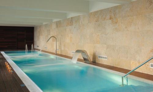 una grande piscina con acqua blu in un edificio di Hostal de la Gavina GL - The Leading Hotels of the World a S'Agaró