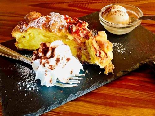 a piece of cake on a black plate with ice cream at Hotel & Ristorante Serenella in Breuil-Cervinia