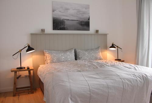 a bedroom with a white bed with two lamps at Fine Home in Timmendorfer Strand