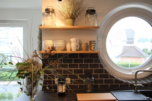 une cuisine avec un miroir et un comptoir orné de plantes dans l'établissement Fine Home, à Timmendorfer Strand