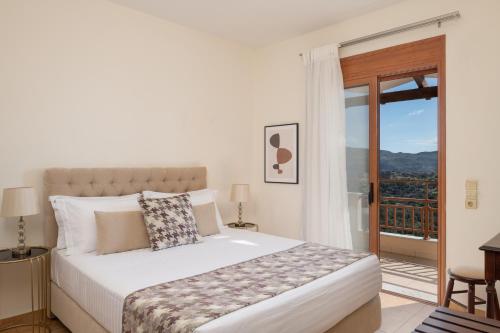 a bedroom with a bed and a balcony at Triopetra Luxury Villas Panagia in Triopetra