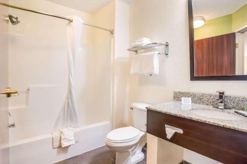 Baño blanco con aseo y lavamanos en Sleep Inn & Suites Jacksonville near Camp Lejeune, en Jacksonville