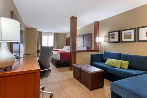 a hotel room with a couch and a bed at Comfort Suites Billings in Billings