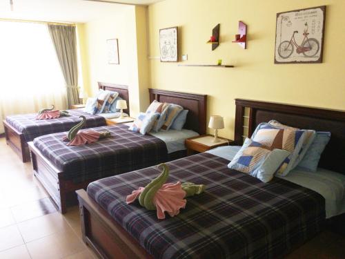 una habitación de hotel con 2 camas con plátanos. en Dos Hemisferios, en Quito