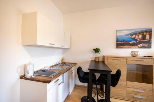 una pequeña cocina con fregadero y mesa en BUDGET City Appartement Küche,Bad, Parken im Zentrum von Ravensburg en Ravensburg