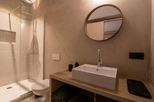 a bathroom with a sink and a mirror and a toilet at Private en-suite room in the heart of Le Sablon in Brussels