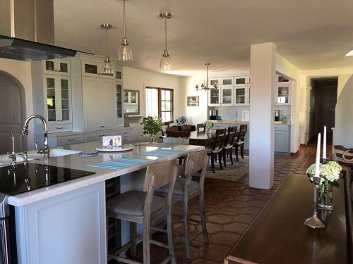 a kitchen and dining room with a large island with chairs at Kate Stanton Inn in Encinitas