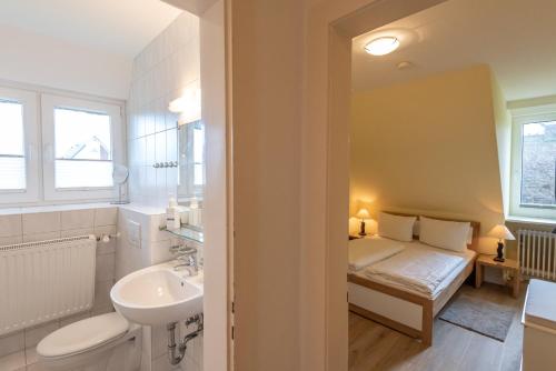 a bathroom with a sink and a bed in a room at Strandhaus Helene in Wenningstedt