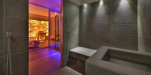 a bathroom with a shower with a bench and a fireplace at Hotel Sporting Family Hospitality in Livigno