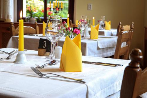 eine Gruppe von Tischen mit gelben Servietten und Kerzen in der Unterkunft Hotel Waldhäusel in Bad Schandau