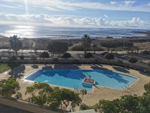 una vista aérea de una piscina y el océano en Modern seafront flat with a private garage, en El Médano