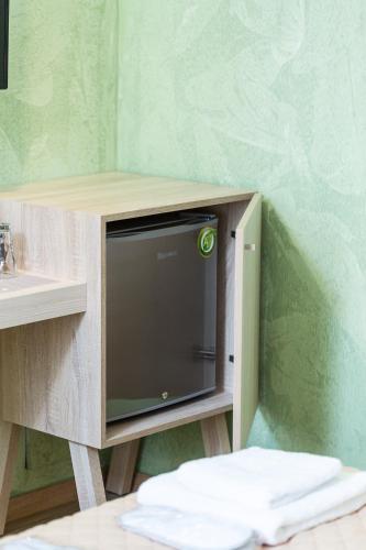 a tv in a wooden cabinet next to a sink at Ark 68 City Rooms in Rethymno Town