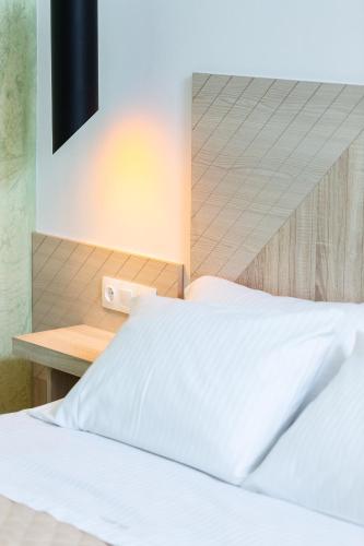 a bedroom with a white bed and a desk at Ark 68 City Rooms in Rethymno Town