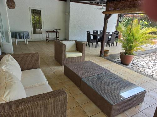 a patio with a couch and chairs and a table at Villa L'Oiseau Bleu in Pereybere