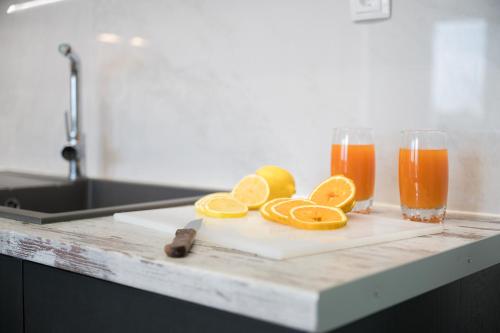 a cutting board with oranges and two glasses of orange juice at Niki Mountain House in Kamariótis